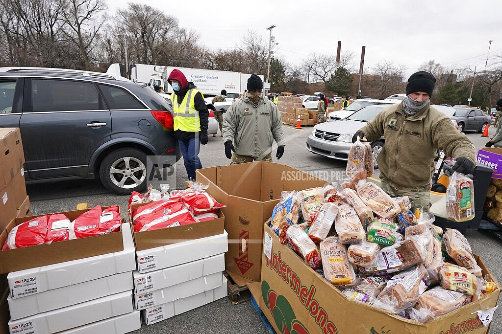 Sgt. Kevin Fowler organizes food at a food bank distribution by the Greater Cleveland Food Bank, Thursday, Jan. 7, 2021, in Cleveland. Food banks across America say these economic conditions are pushing demand for their support higher, at a time when their labor and delivery costs are climbing and donations are decreasing. The problem has grown to the point that President Joe Biden called for a Conference on Hunger, Nutrition and Health in September, the first since 1969/ (AP Photo/Tony Dejak, File)