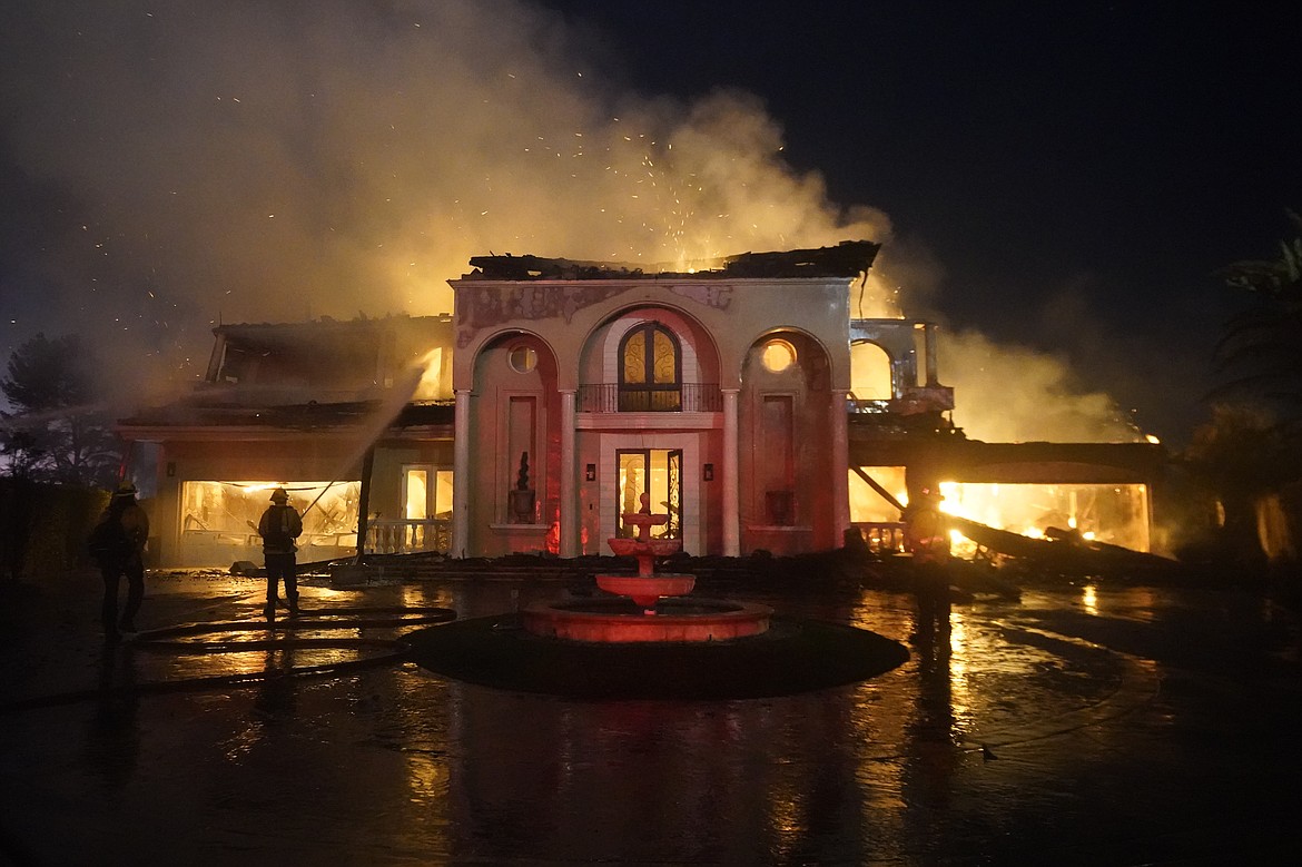 Firefighters work to put out a structure burning during a wildfire Wednesday, May 11, 2022, in Laguna Niguel, Calif. (AP Photo/Marcio J. Sanchez)