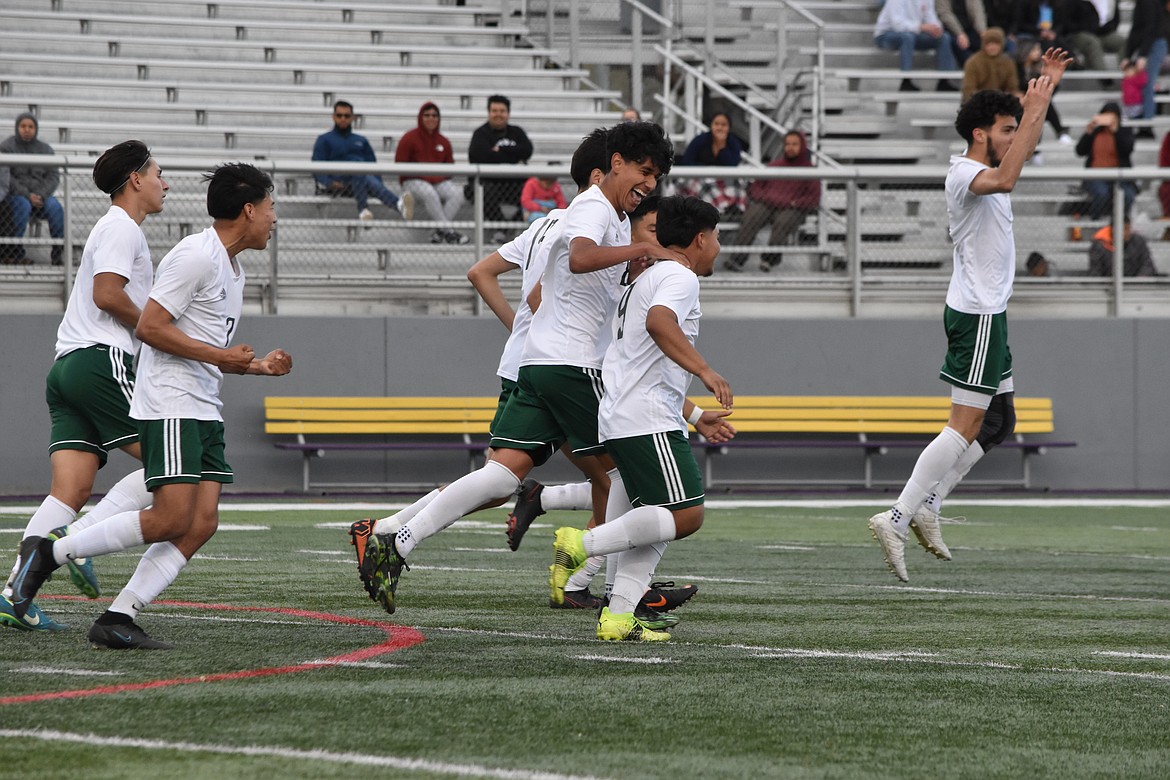 Quincy junior Jorge Nunez (9) works the ball around a Bridgeport opponent before scoring a goal during the district matchup on Wednesday.