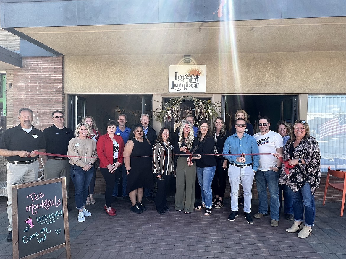 Jenna Hildebrand, owner of Love & Lumber at 121 W. Third Avenue in downtown Moses Lake, is joined by members of the Moses Lake Chamber of Commerce on Wednesday to cut the ribbon and formally mark the grand opening of Love & Lumber’s teahouse.