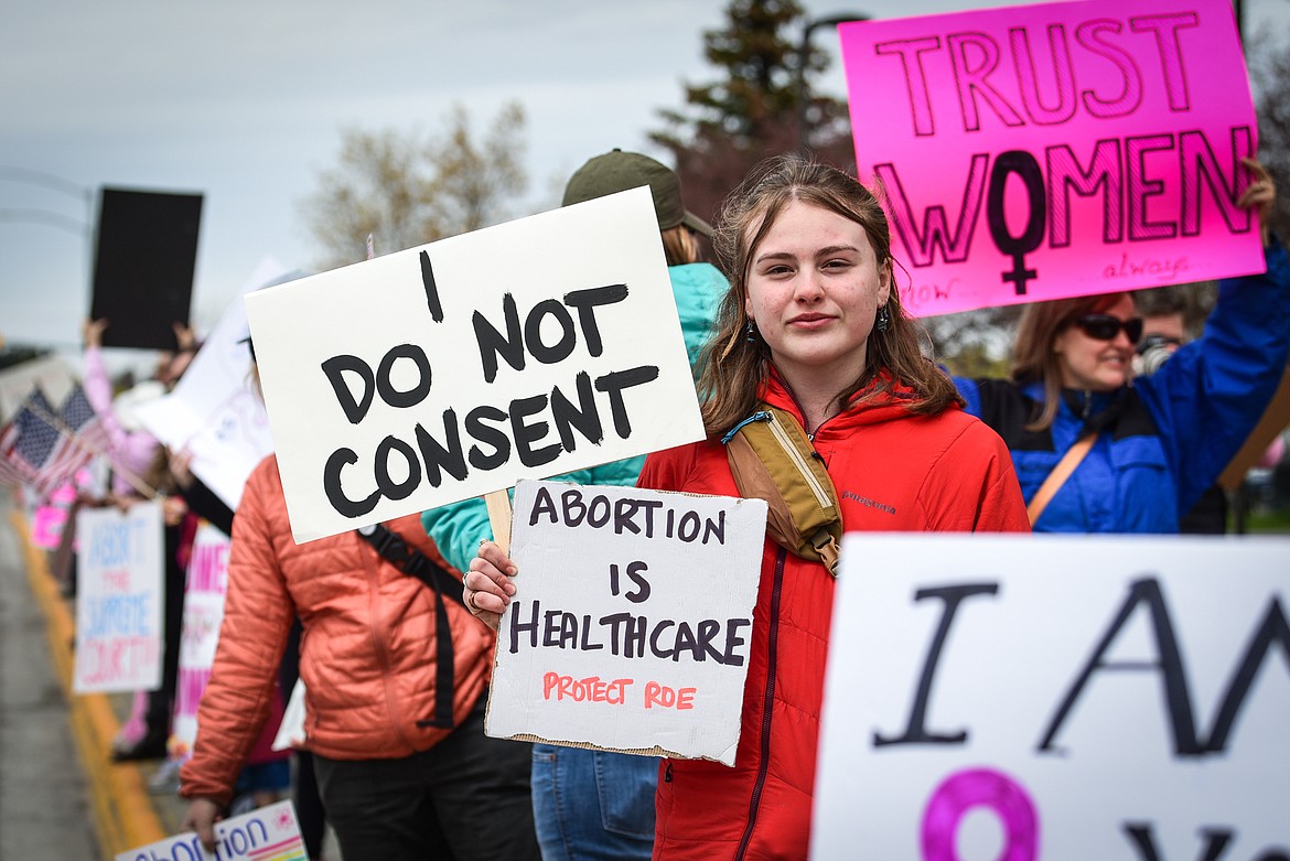 Attendees hold signs and wave flags during the Flathead Valley Women's Reproductive Rights March at Depot Park in Kalispell on Saturday, May 14. (Casey Kreider/Daily Inter Lake)