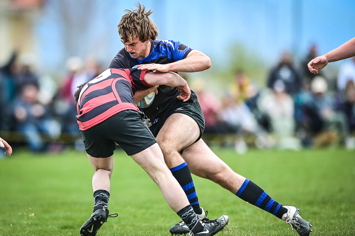 Flathead Valley Black and Blue's Luke Leech (4) is brought down by a Missoula Mud Dog defender during the championship game of the State Rugby Tournament at Glacier High School on Saturday, May 14. (Casey Kreider/Daily Inter Lake)