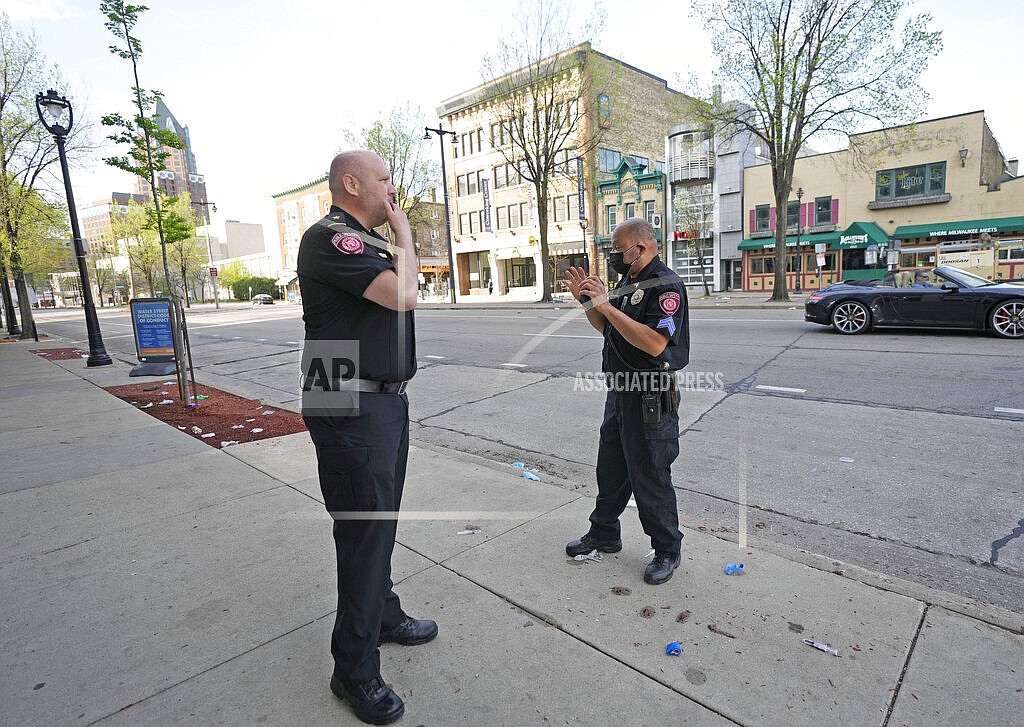 MSOE Public Safety officers investigate the scene of a shooting near the corner of North Water Street and East Juneau Avenue in Milwaukee, Saturday, May 14, 2022, where multiple were shot and injured late Friday in Milwaukee's downtown bar district after the Milwaukee Bucks playoff game. Authorities say multiple people were injured in two shootings in downtown Milwaukee near an entertainment district where thousands of people were watching the Bucks play the Celtics in the NBA’s Eastern Conference semifinals. (Mike De Sisti/Milwaukee Journal-Sentinel via AP)