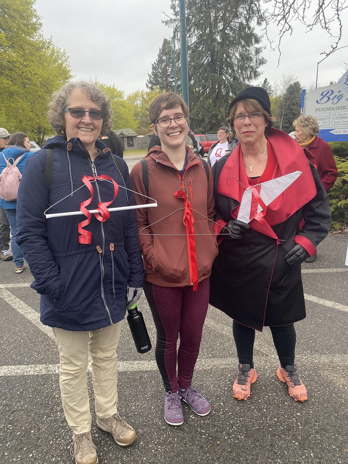 Participants in the women's march Saturday chanted and carried signs. For Karine Nelson (from left), daughter Aimee Croteau and friend Lynn Fleming, metal coat hangers expressed their message.