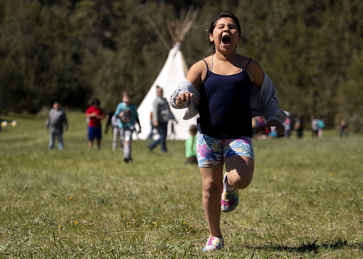 Johnnie James, a fourth grader at Pablo Elementary, participates in the run-and-scream game during the 35th annual River Honoring near Moiese, Mont., on May 11, 2022. Elementary students from schools on the Flathead Reservation participated in educational events about natural and cultural resources on the Flathead River. About 400 children a day attended the two-day event. (Ben Allan Smith/The Missoulian via AP)