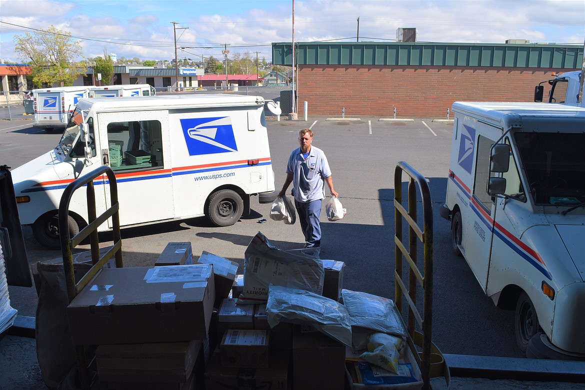 Letter Carrier Derick Rhodes brings in several bags of food from her route on Saturday as part of the Stamp Out Hunger food drive staged by the National Association of Letter Carriers every year on the second Saturday in May.