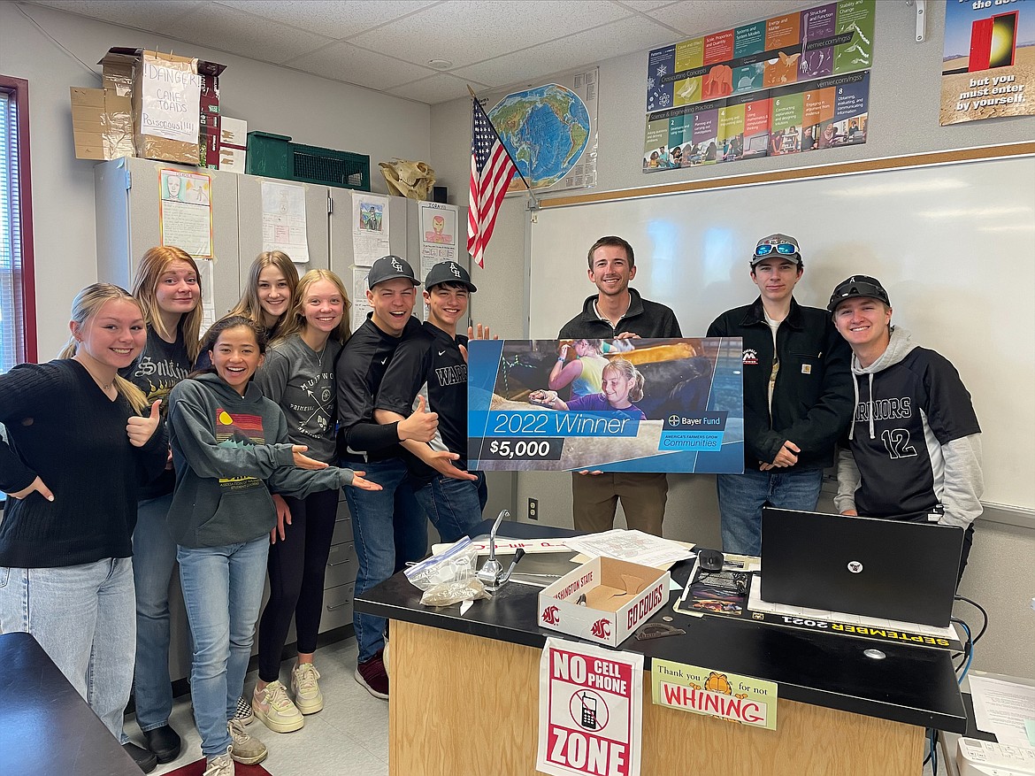 Hunter Lee, ACH science teacher, holding the grant check with some of his students.