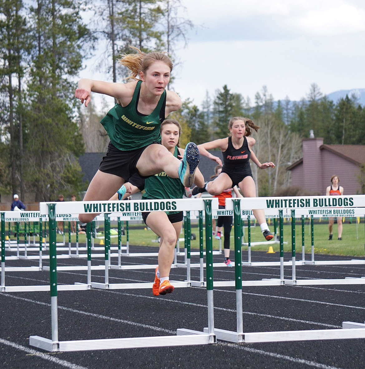 Bulldog Maeve Ingelfinger races to first place in the 100 meter hurdles at the Whitefish Triangular meet on Thursday. (Matt Weller photo)