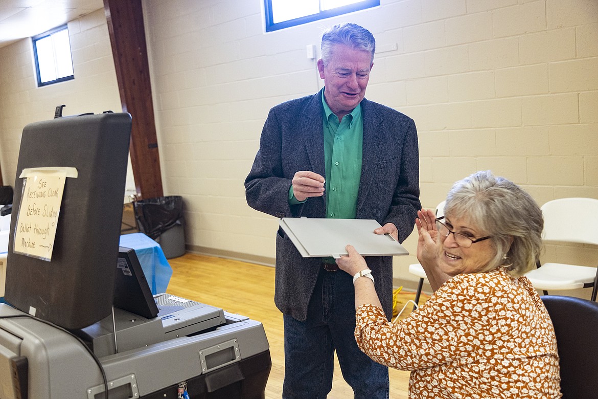 Idaho Gov. Brad Little laughs as he takes an "I Voted" sticker from poll worker Carla Stark after casting his ballot in Idaho's Primary Election in Emmett on Tuesday.