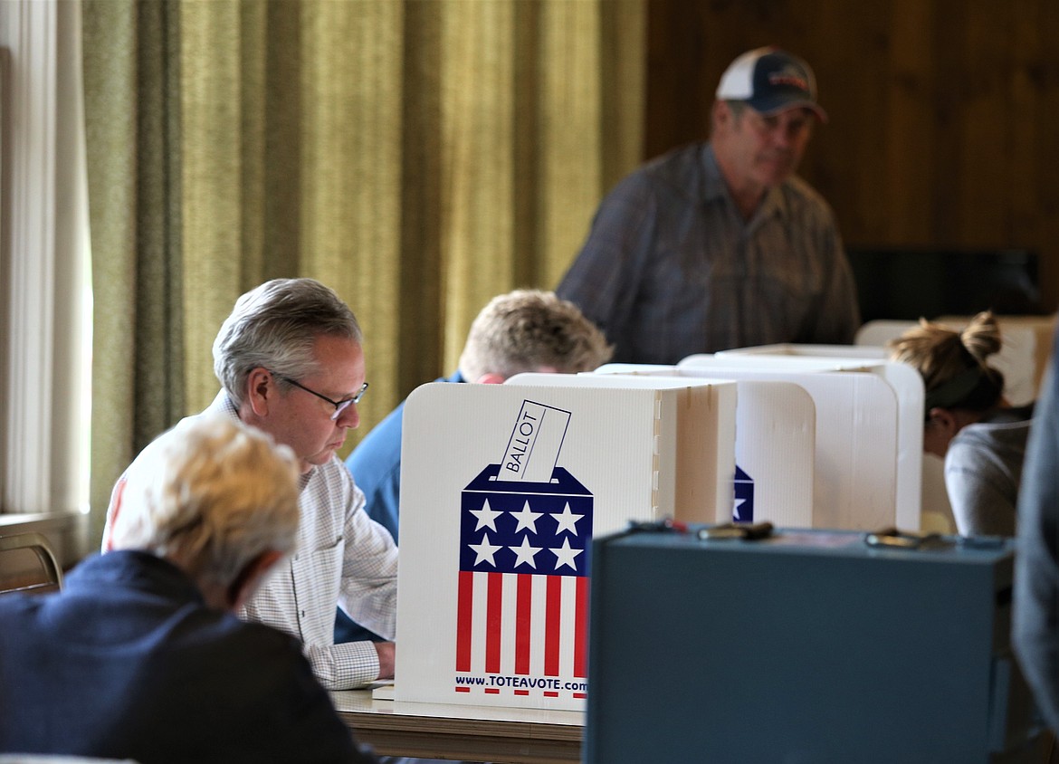 Voters fill out ballots for Idaho's preliminary election on Tuesday at the Mica Flats Grange.