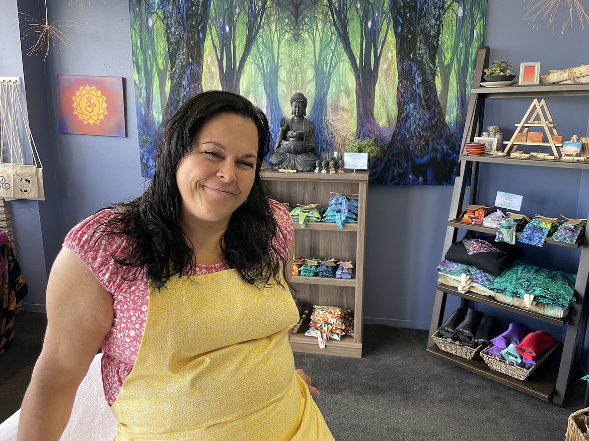 Amy Jean Winter, owner of Seeds 'n Stone Natural Therapeutic Products in Moses Lake, sits on a massage table in the main room of her new shop, which opened in late April.