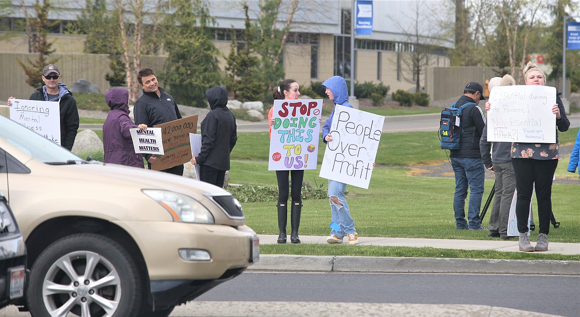 People protesting Kootenai Health's plans to close its inpatient addiction recovery program and outpatient psychiatry practice hold signs outside Kootenai Health on Wednesday.