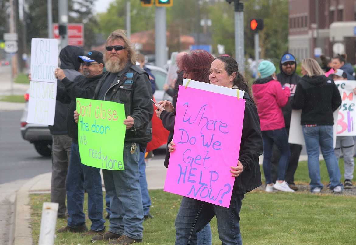 Maureen McKenzie stands along U.S. 95 with a sign during a protest outside Kootenai Health on Wednesday.