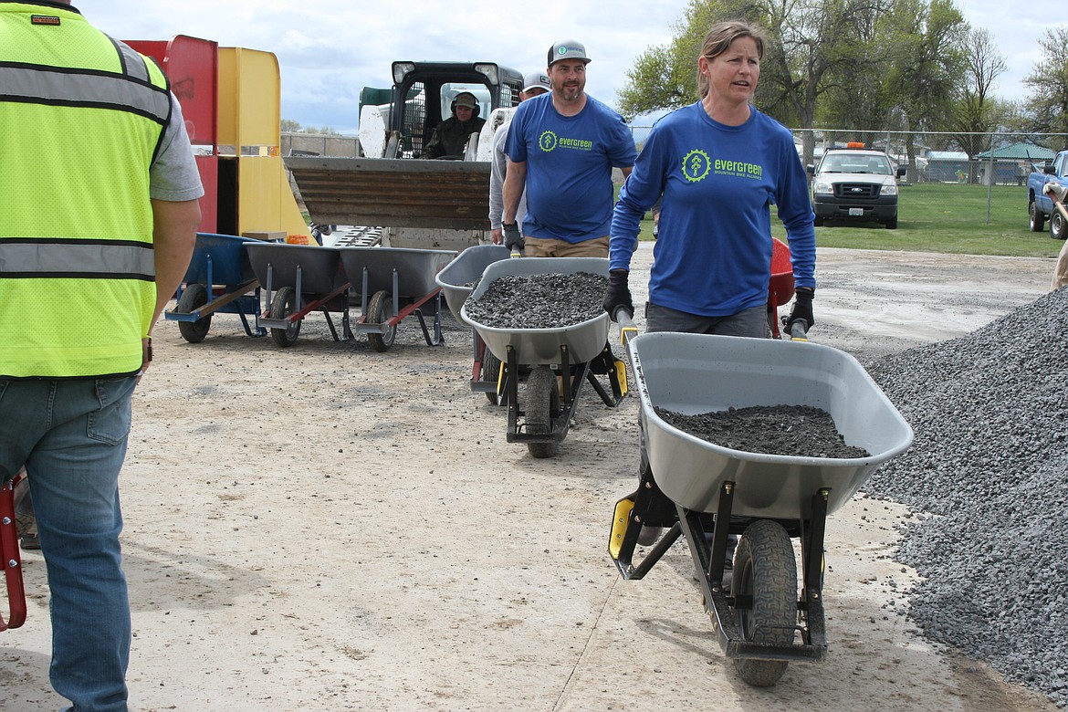 Volunteers and Quincy city workers head out with loads of rock to be spread on the pump track on May 6. The rock sets a foundation for asphalt to be added later in the construction process.