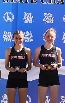 Photo courtesy of RICHARD WOOD
Post Falls High junior Annastasia Peters, left, and senior Sammie Wood receive their medals following the state 5A girls 3,200-meter run at Dona Larsen Park in Boise. Wood won the race, followed by Peters in second.