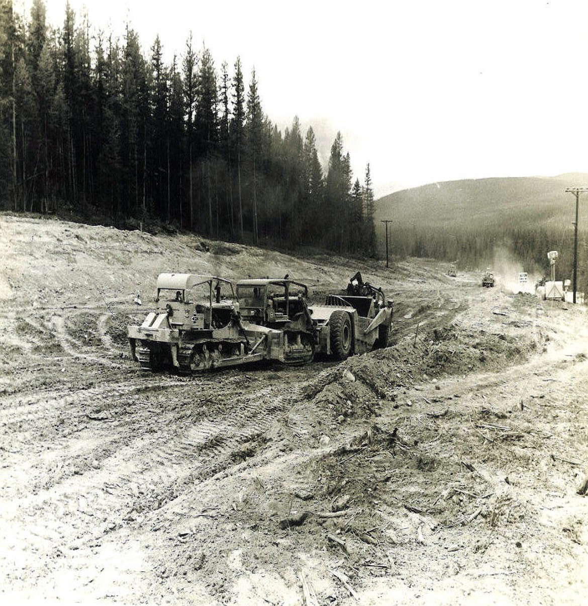 A scraper being pushed by two caterpillars, creating the grade that came into the south portal of the Flathead Tunnel during its construction (Bruce Morse photo)