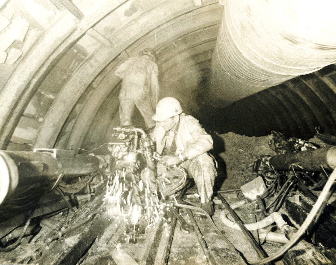 Herb Morse cuts off a drill that was stuck in the wall during the construction of the Flathead Tunnel. Anyone who stuck a drill would have to buy a case of beer for the rest of the workers. (Bruce Morse photo)