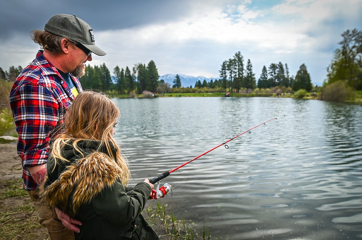 Mike Edwards fishes with his daugther Jayne at the Brooke Hanson Memorial Family Fishing Day at Pine Grove Pond on Saturday, May 21. Hundreds of prizes were donated by area merchants and sportsmen's groups to be awarded to kids 12 and under. The event was sponsored by Flathead Wildlife and donations go to enhancing fishing opportunities around the Flathead in Brooke Hanson's memory. (Casey Kreider/Daily Inter Lake)