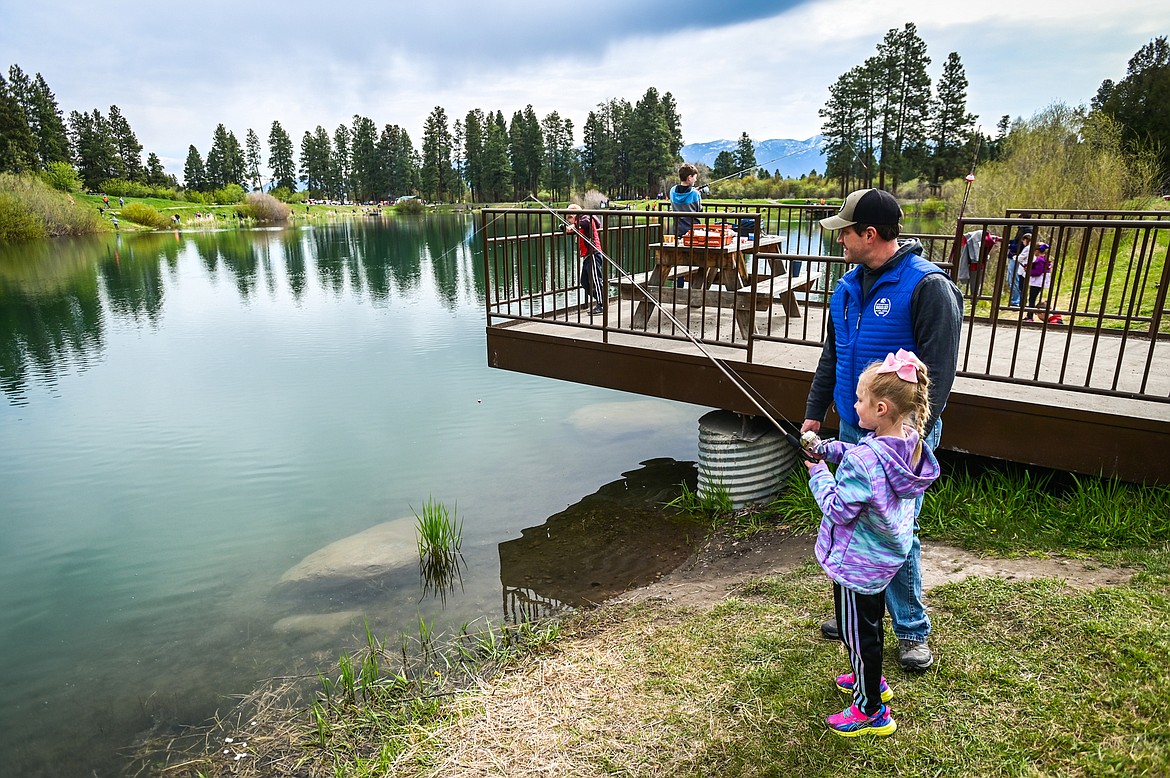 Andy Ferdinand fishes with his daugther Sadie at the Brooke Hanson Memorial Family Fishing Day at Pine Grove Pond on Saturday, May 21. Hundreds of prizes were donated by area merchants and sportsmen's groups to be awarded to kids 12 and under. The event was sponsored by Flathead Wildlife and donations go to enhancing fishing opportunities around the Flathead in Brooke Hanson's memory. (Casey Kreider/Daily Inter Lake)