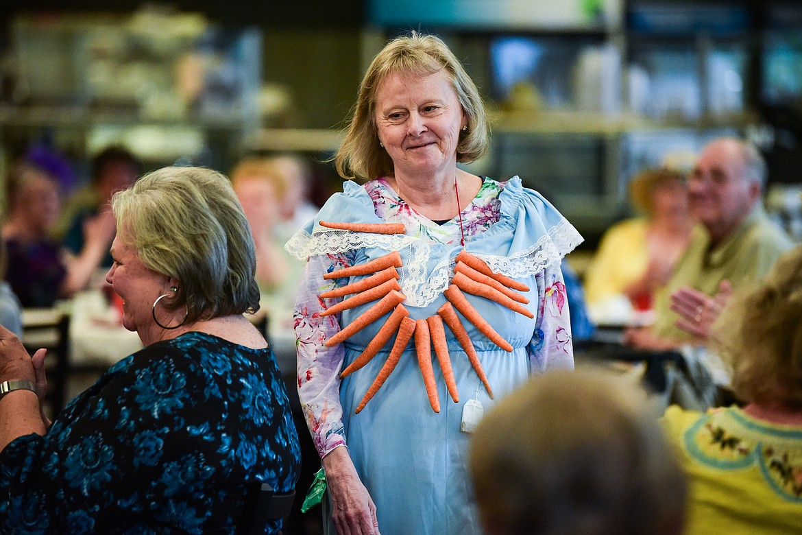 A model wears a comical fashion creation with a "fourteen carrot necklace" during the May Tea & Style Show at the Kalispell Senior Center on Saturday, May 21. The annual fundraiser requires about 20 volunteers and the style show, a mock fashion show, is written, coordinated and designed by resident Rosainne Taylor. (Casey Kreider/Daily Inter Lake)