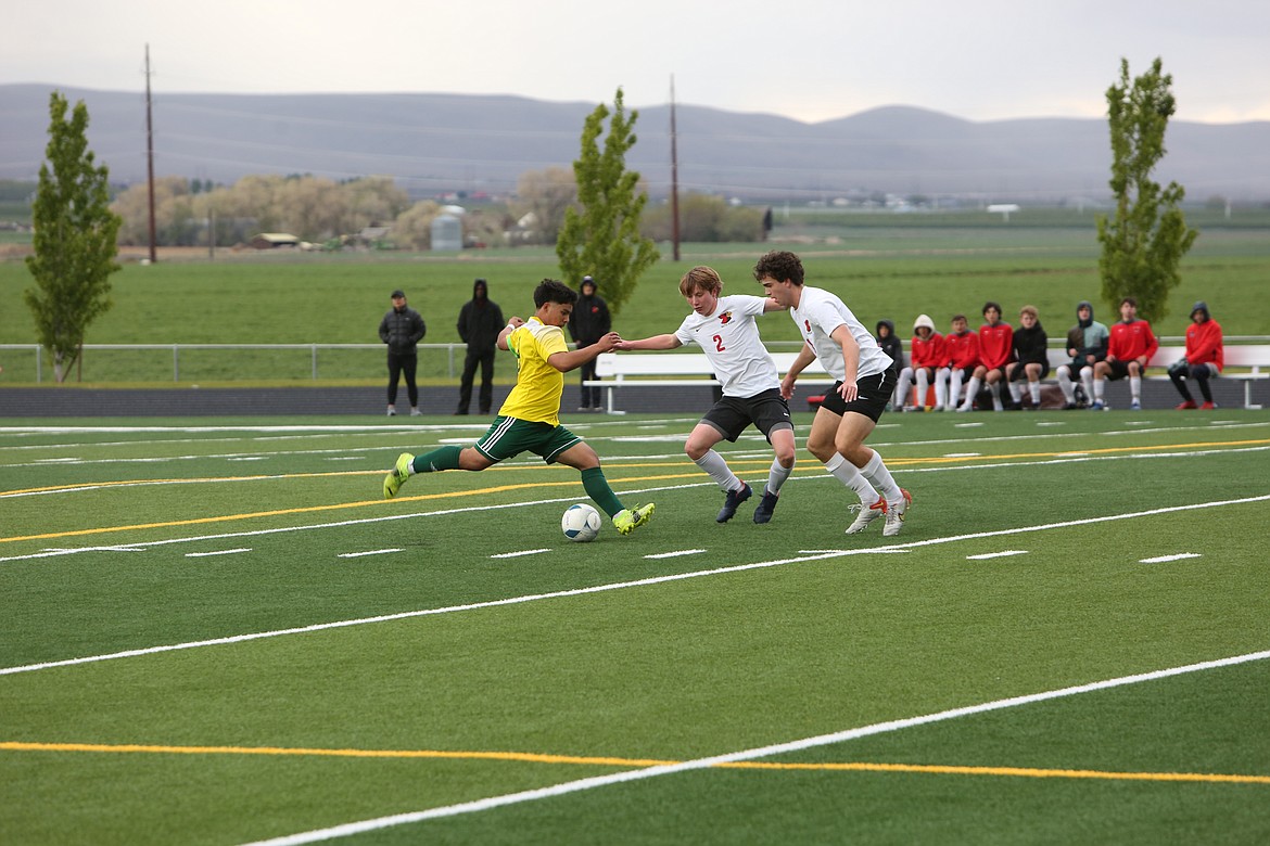 Junior forward Jorge Nunez passes the ball to a teammate while pressured by two Seattle Academy defenders on May 20, 2022.