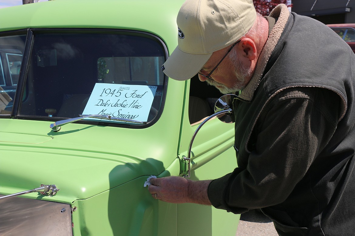 Dale Hire of Moyie springs wipes away some dust away from his 1945 Ford after bringing the classic car to Sandpoint for Lost in the '50s.