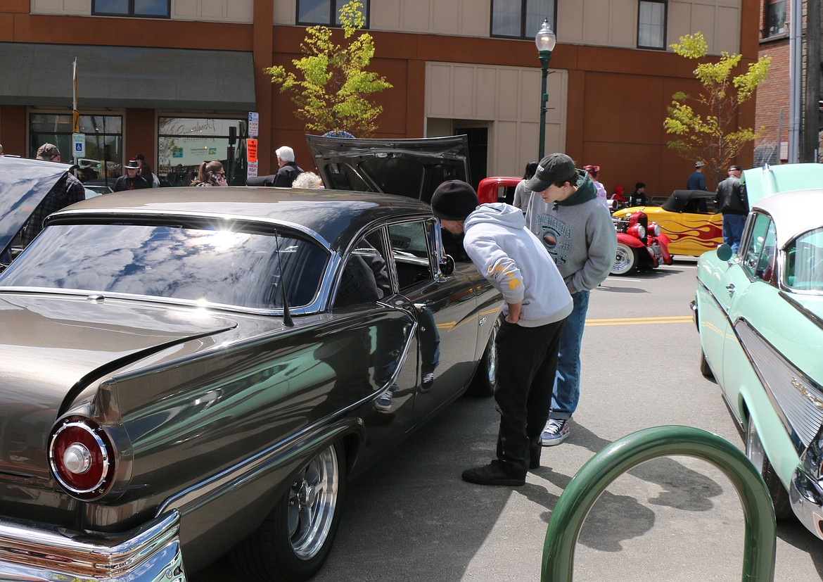 A pair peek through a window as they admire a classic car during the Lost of the '50s car show in Sandpoint on Saturday.