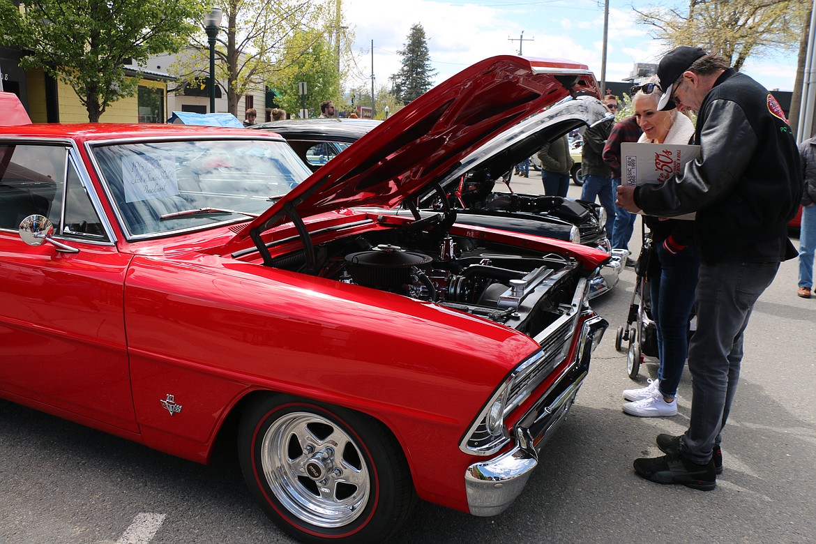 Ron and Kim Bennett look over a 1967 Chevy Nova SS owned by Jack and Susie Shiplett of Pinehurst as they help with judging at the Lost in the '50s car show in Sandpoint on Saturday, May 21.