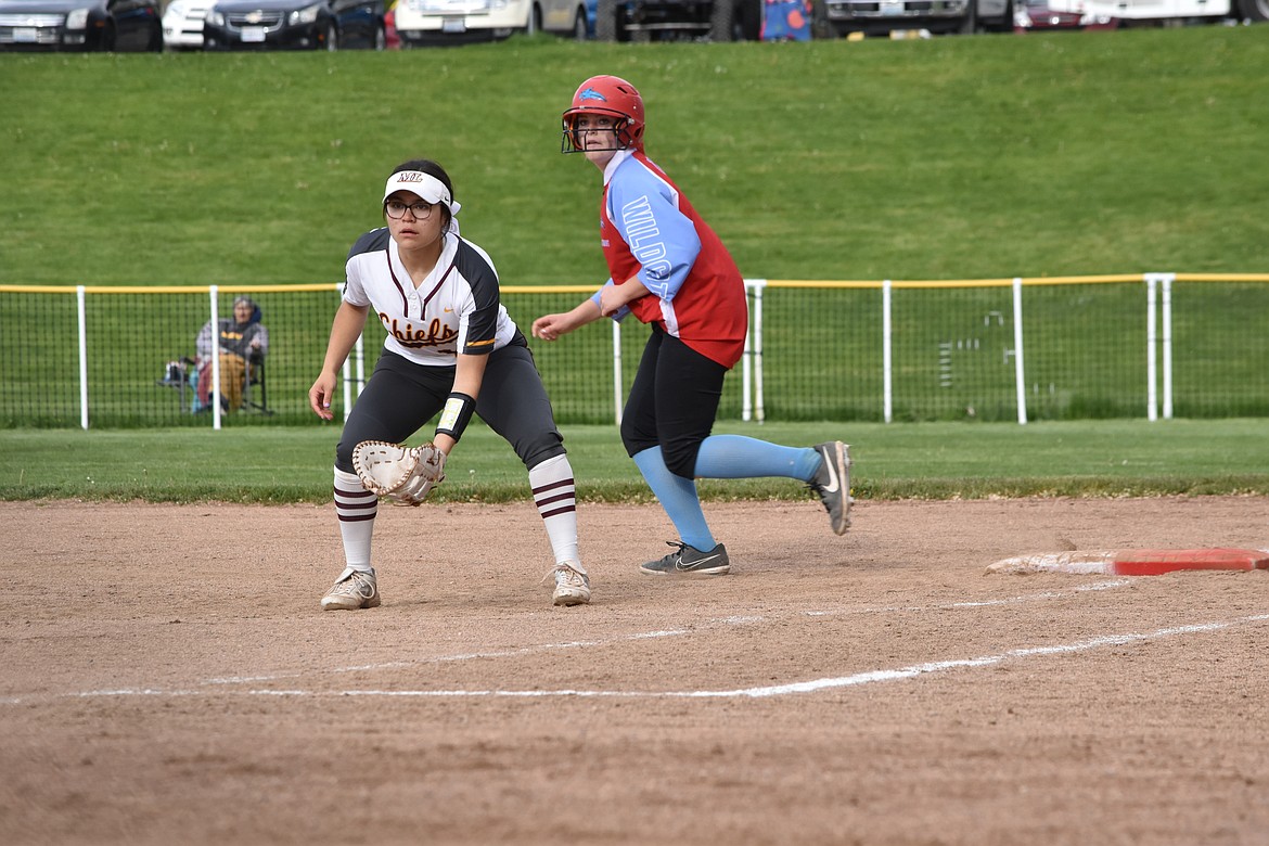 Moses Lake senior Rylie Sanchez (12) stays at the ready while an Eastmont opponent takes a lead off first base during the district matchup on Friday.