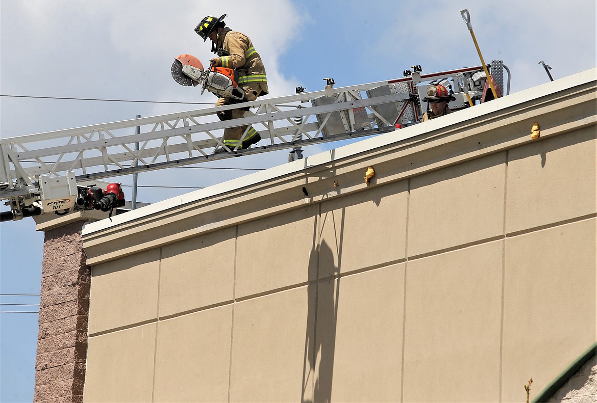 Firefighters leave the rooftop of the former Black Sheep Sporting Goods building during a training exercise on Sunday.
