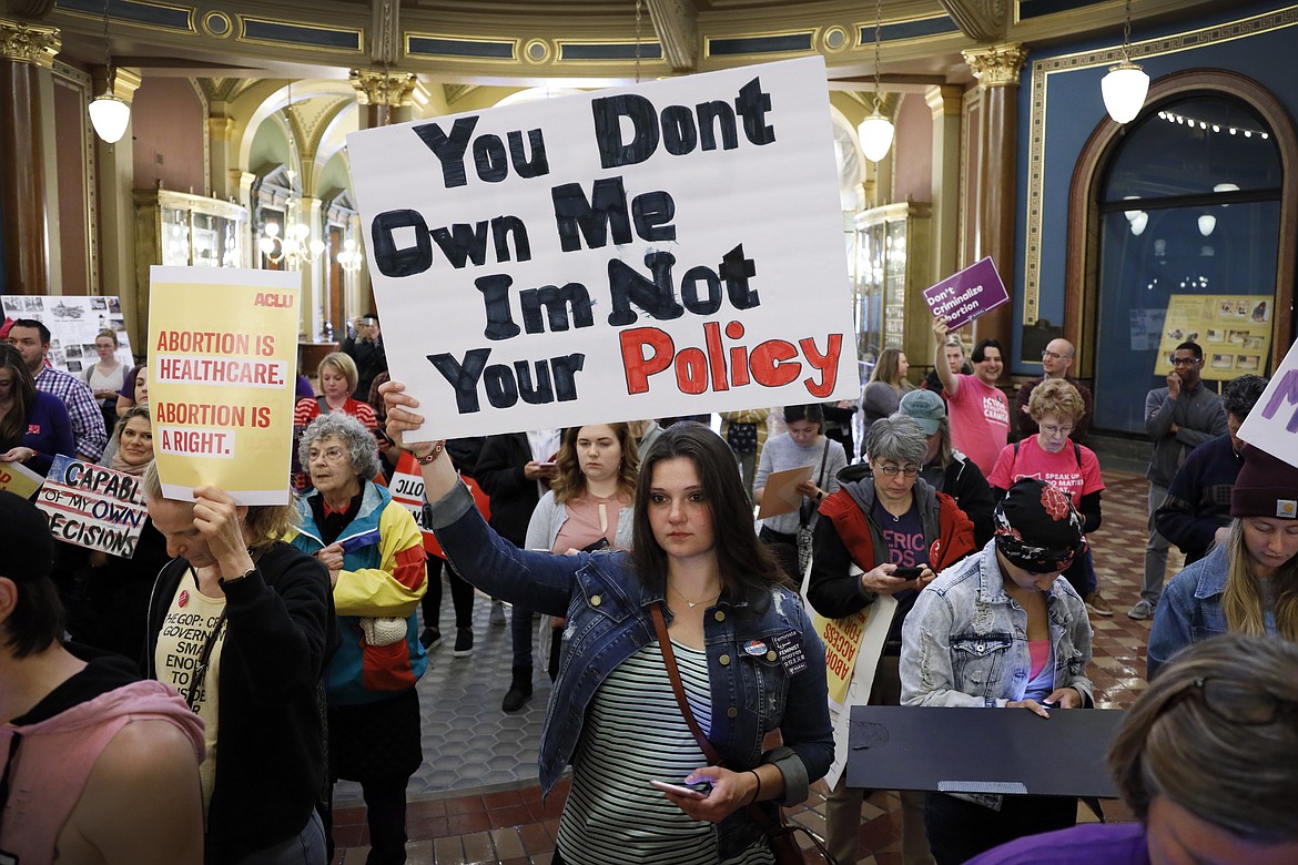 Marissa Messinger, of Lake View, Iowa, center, holds a sign during a rally to protest recent abortion bans, May 21, 2019, at the Statehouse in Des Moines, Iowa. With a devoutly anti-abortion Republican governor and large GOP legislative majorities, Iowa would seem poised to easily ban abortion if the U.S. Supreme Court overturns Roe v. Wade. (AP Photo/Charlie Neibergall, File)