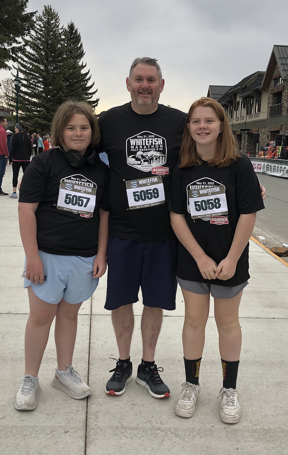 Twins Kate and Orla Sullivan, sixth graders at Whitefish Middle School, gave it their all this weekend racing their first 5K at the Whitefish Marathon event. Pictured with their step-dad Kenny Ross. (Photo submitted by Claire Sullivan)