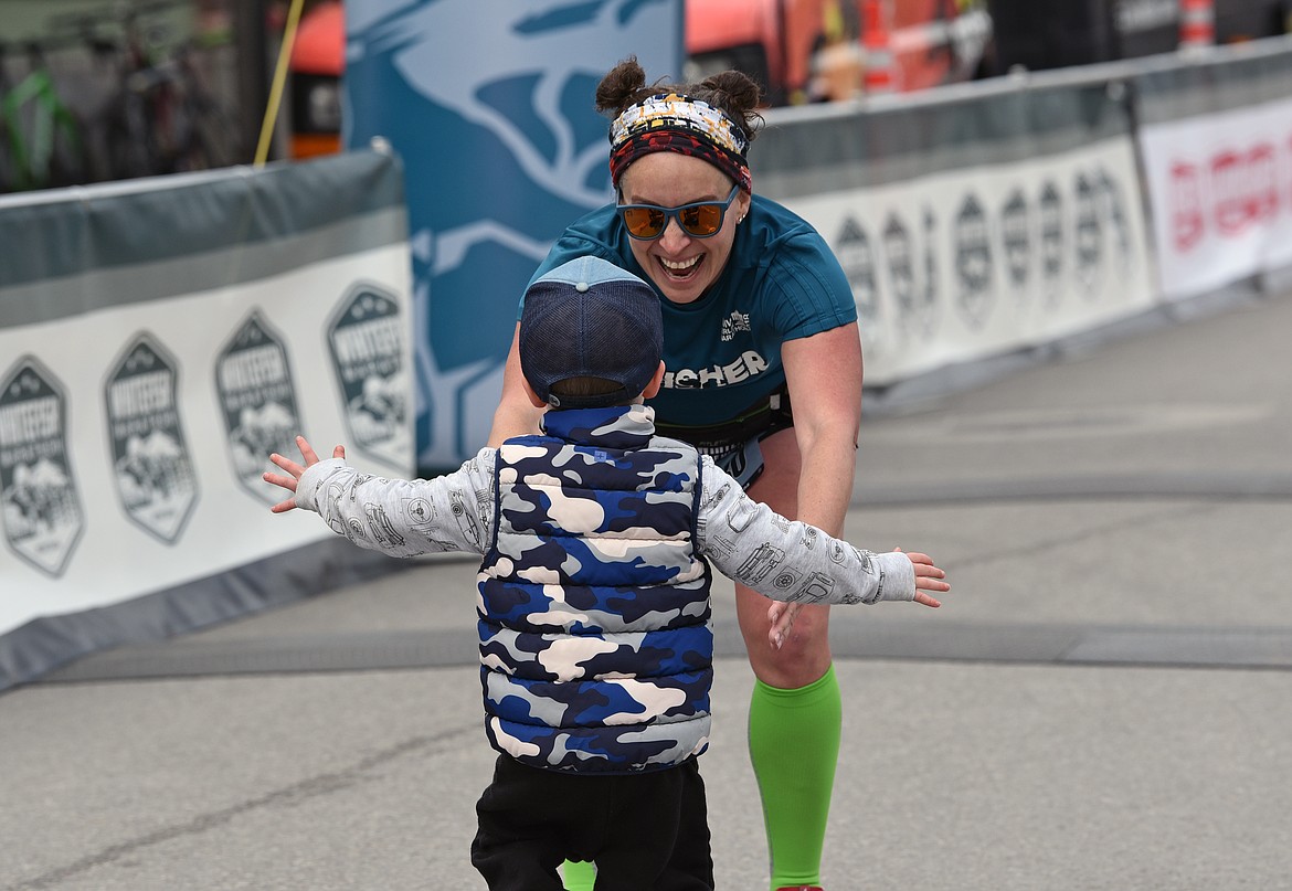 Andrea Lammers-Pottage from Lethbridge, Alberta is greeted by her young fan after crossing the finish line at the Whitefish Marathon on Saturday. (Whitney England/Whitefish Pilot)