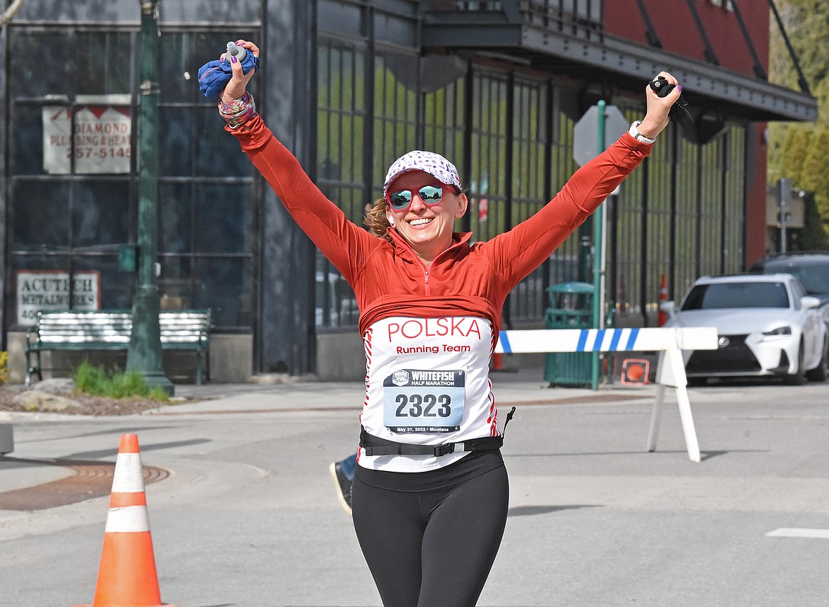 Jolanta Thorburn from Kirkland, Washington celebrates a successful race during the Whitefish Marathon event downtown on Saturday. (Whitney England/Whitefish Pilot)