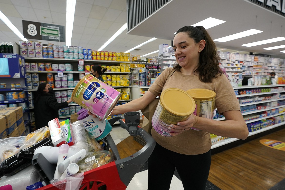 Michelle Saenz of Santee, Calif. buys baby formula at a grocery story across the border, Tuesday, May 24, 2022, in Tijuana, Mexico. As the baby formula shortage continues in the United States, some parents are opting to cross the border into Mexico, where the shelves are still stocked with options to feed their babies. (AP Photo/Gregory Bull)