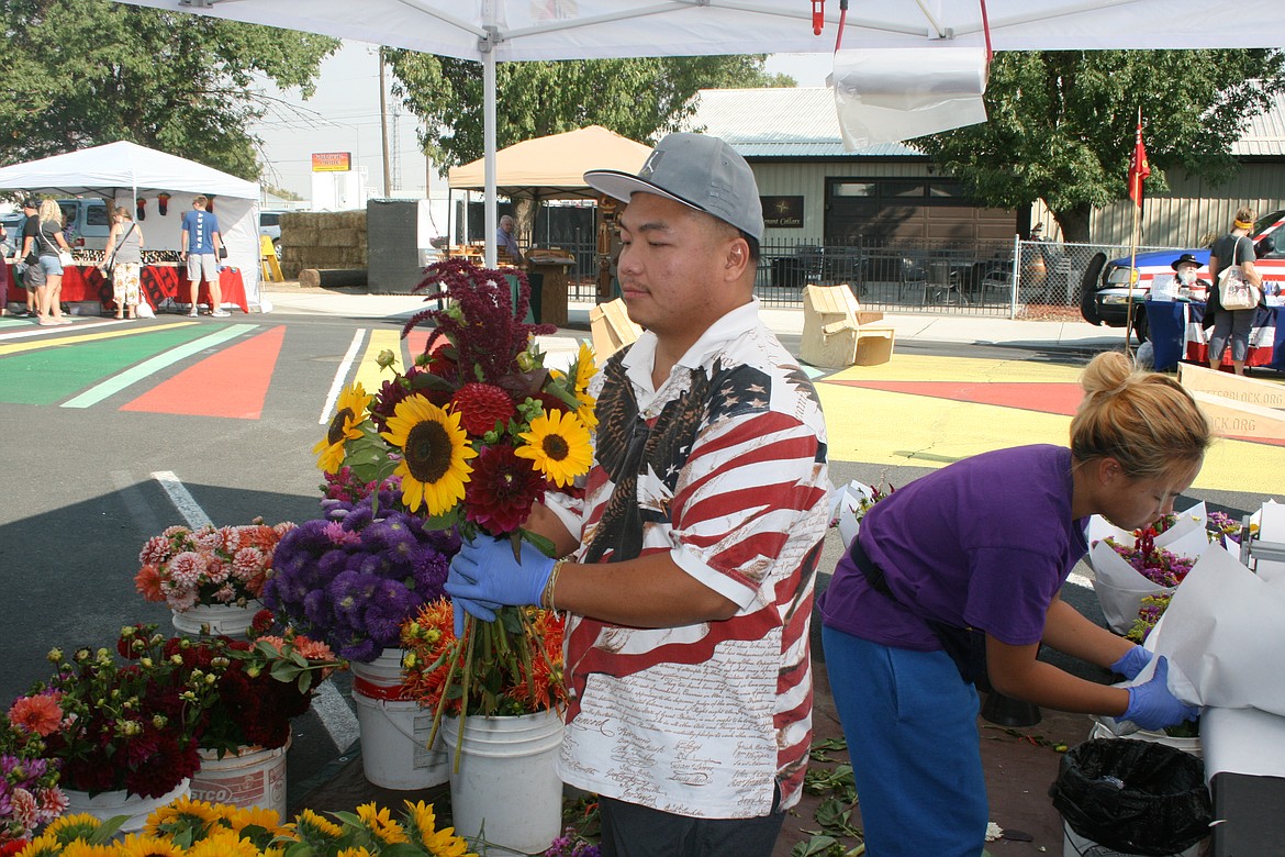 Vendor Ma Yang, Snohomish, prepares a fresh bouquet at the B Street Market in Quincy in September 2021. Market managers will be adding more Saturdays in 2022.