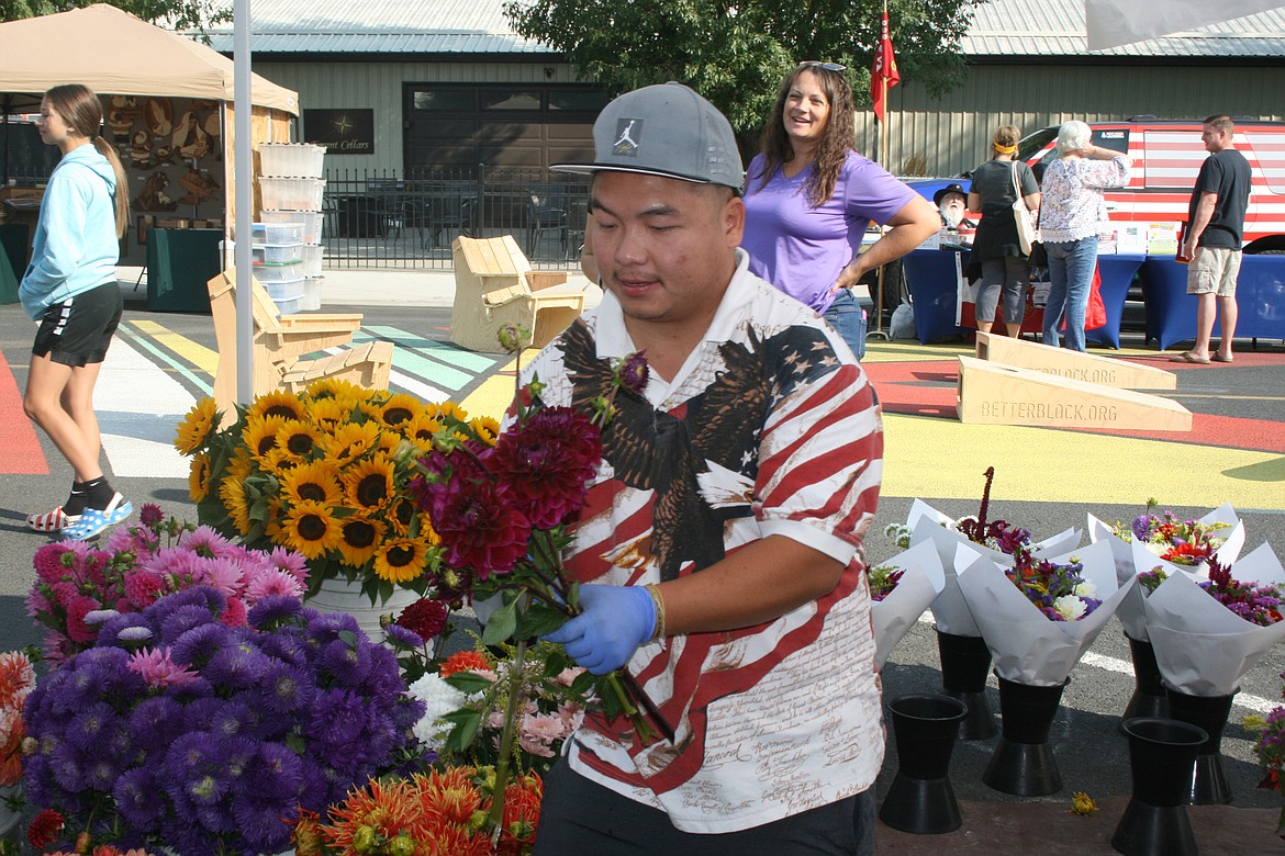 Ma Yang, a vendor from Snohomish, prepares a bouquet during a September 2021 B Street Market in Quincy. Market managers will be adding more Saturdays in 2022.