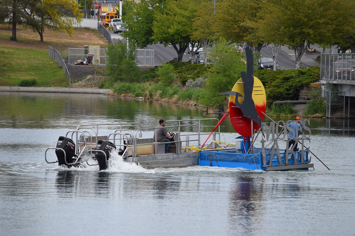 A crew with the Moses Lake Irrigation and Rehabilitation District tow the fountain out into the lake near the Alder Street Fill on Wednesday, a sure sign that summer is coming.