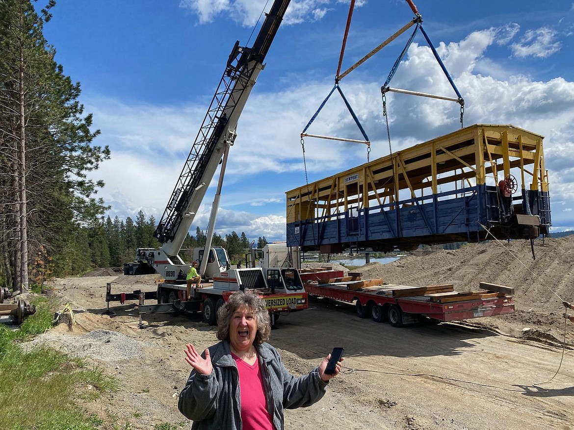 Karen Hansen screams with joy on May 20 as the train car she and her husband, Mike, purchased is delivered to their backyard railroad tracks.