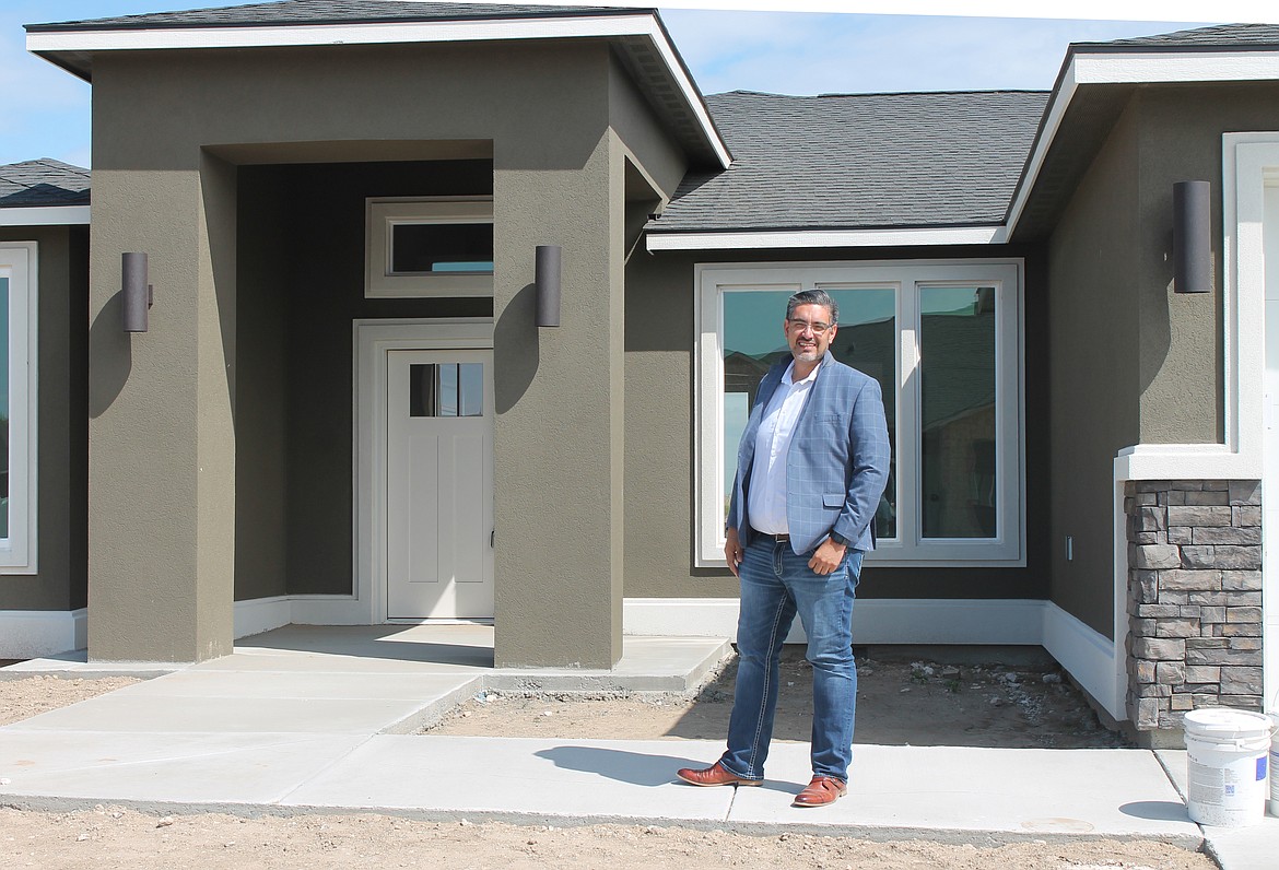 Imagine Realty broker Jessie Dominguez stands in front of a Palos Verdes house in the Sandhill Estates development in Othello.