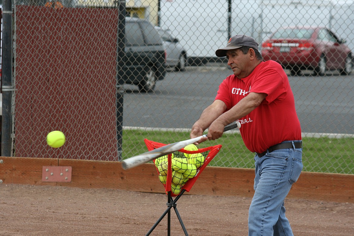 Othello fastpitch softball head coach Rudy Ochoa hits grounders to the team during Tuesday’s practice.