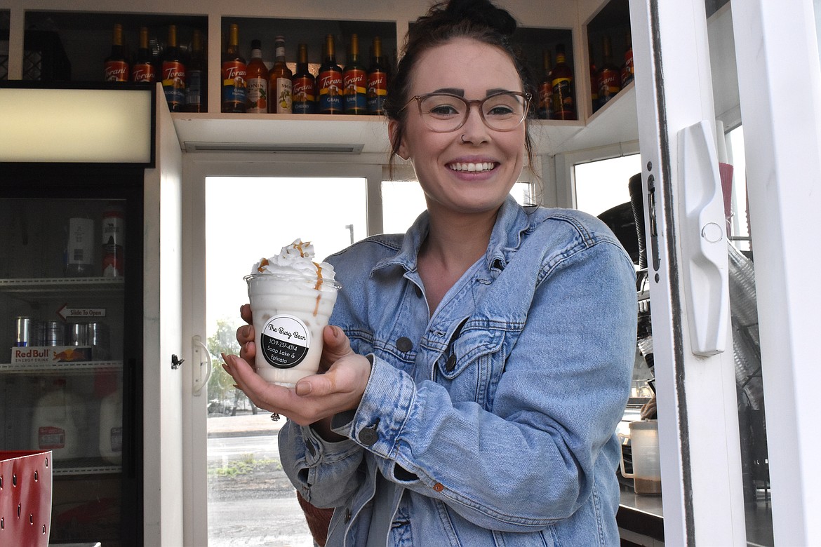 Kenzie Balentine, owner of The Busy Bean, poses with a cup of her coffee.
