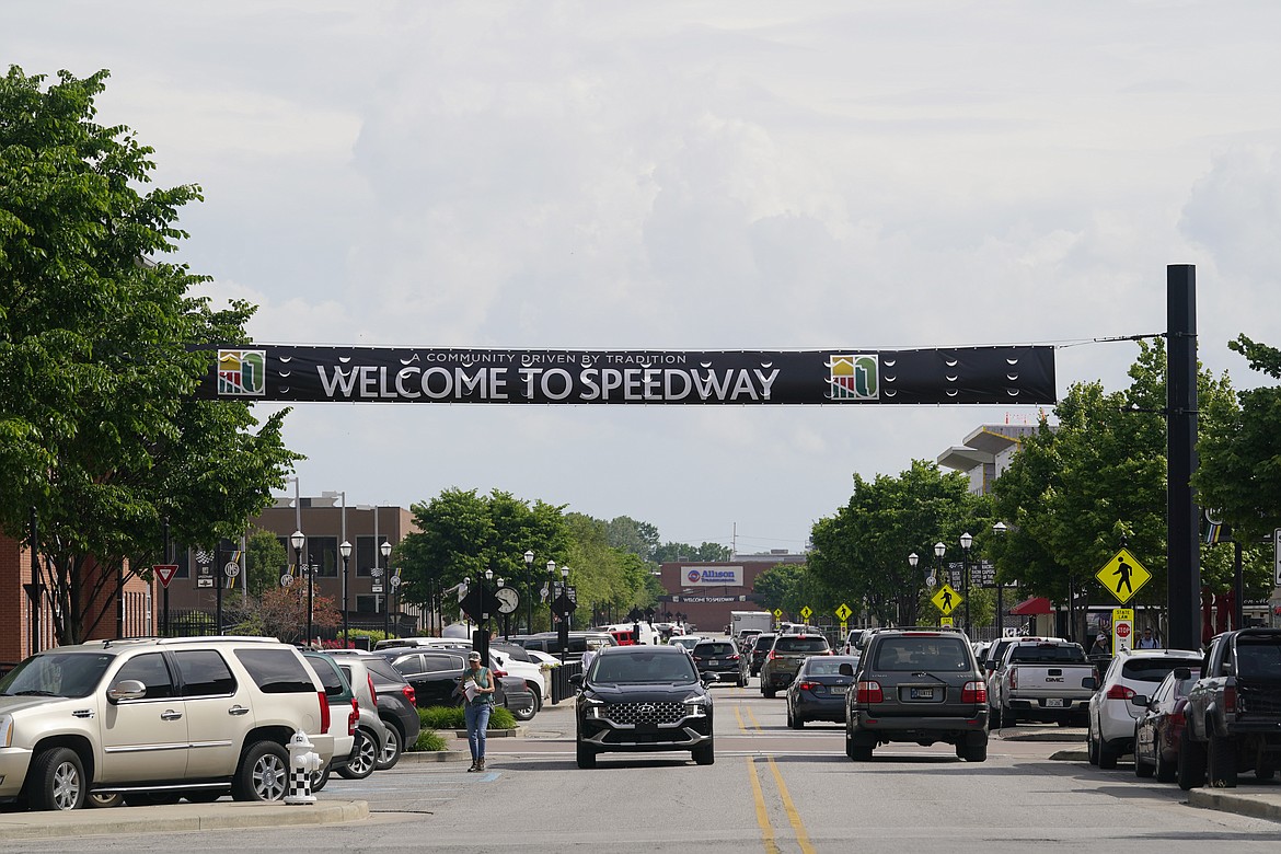 Motorist drive on Main Street through downtown Speedway, Ind, Wednesday, May 25, 2022. For two years, COVID-19 restrictions made those crowds and that revenue almost non-existent. Now, with the Indianapolis 500 finally back to full capacity, the fans and dollars are flowing back home again and spurring a much needed economic boom. (AP Photo/Darron Cummings)