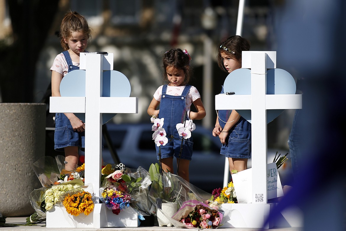 Children pay their respects at a memorial site for the victims killed in this week's elementary school shooting in Uvalde, Texas, Thursday, May 26, 2022. (AP Photo/Dario Lopez-Mills)