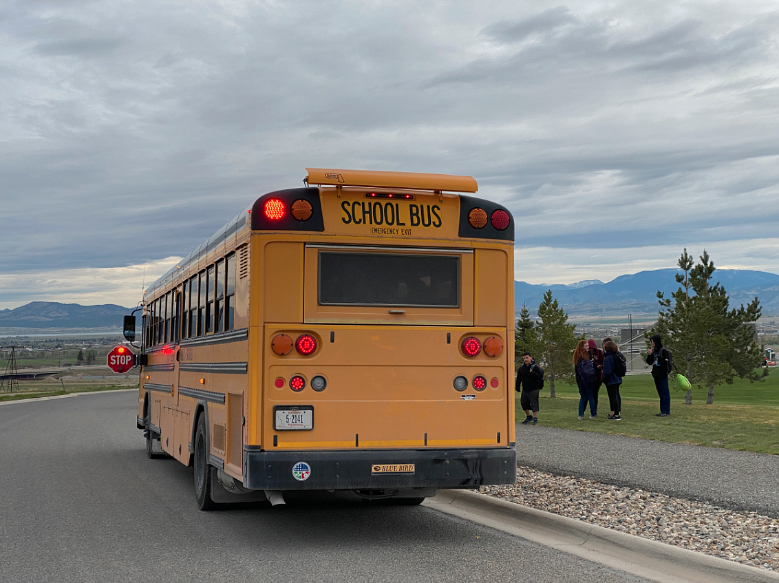 A school bus with it's stop arm deployed and its flashing lights actuated picks up East Helena School District students at Mountain View Park on Wednesday, May 25. This is the spot where Montana Superintendent of Public Instruction Elsie Arntzen allegedly illegally passed by a school bus on May 19. (John S. Adams/MTFP)