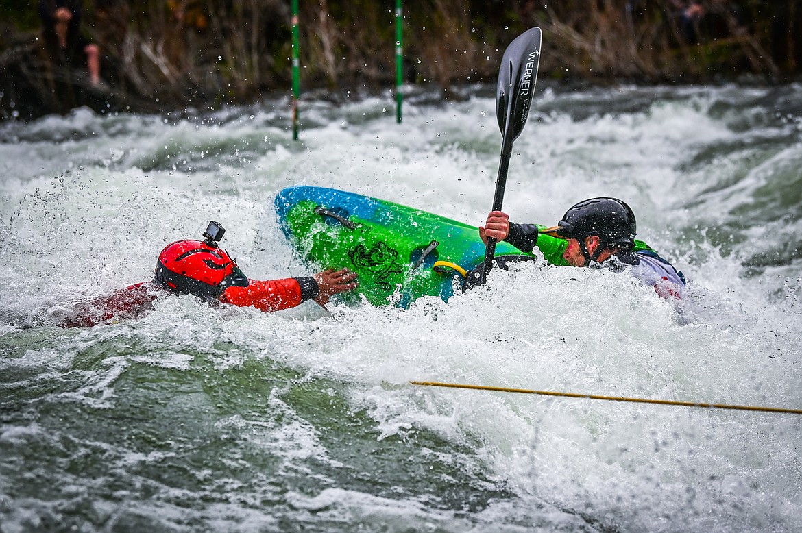 A volunteer rescue kayaker, left, leapt into the Swan River to help a competitor out of a hole during the Expert Slalom event at the 47th annual Bigfork Whitewater Festival on Saturday, May 28. (Casey Kreider/Daily Inter Lake)