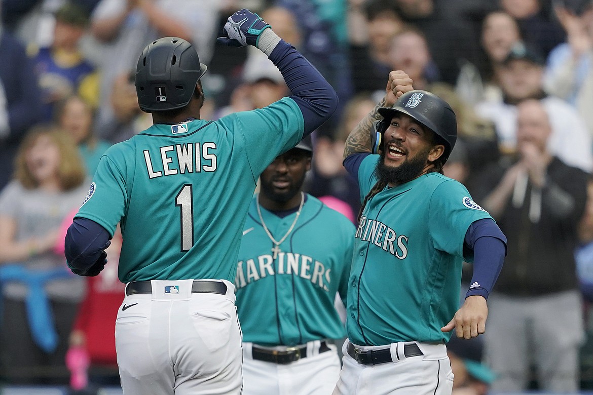 Seattle Mariners' Kyle Lewis (1) is greeted at the dugout by J.P. Crawford, right, after Lewis hit a two-run home run to score Crawford against the Houston Astros during the first inning of a baseball game Friday, May 27, 2022, in Seattle.