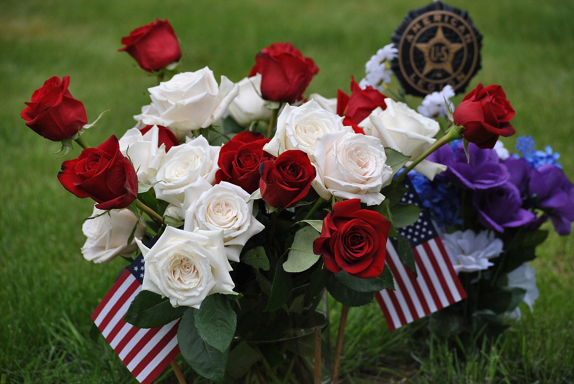 A vibrant arrangement of fresh red and white roses along with small American flags decorate a grave at the St. Regis Cemetery this past Memorial Day weekend. (Amy Quinlivan/Mineral Independent)