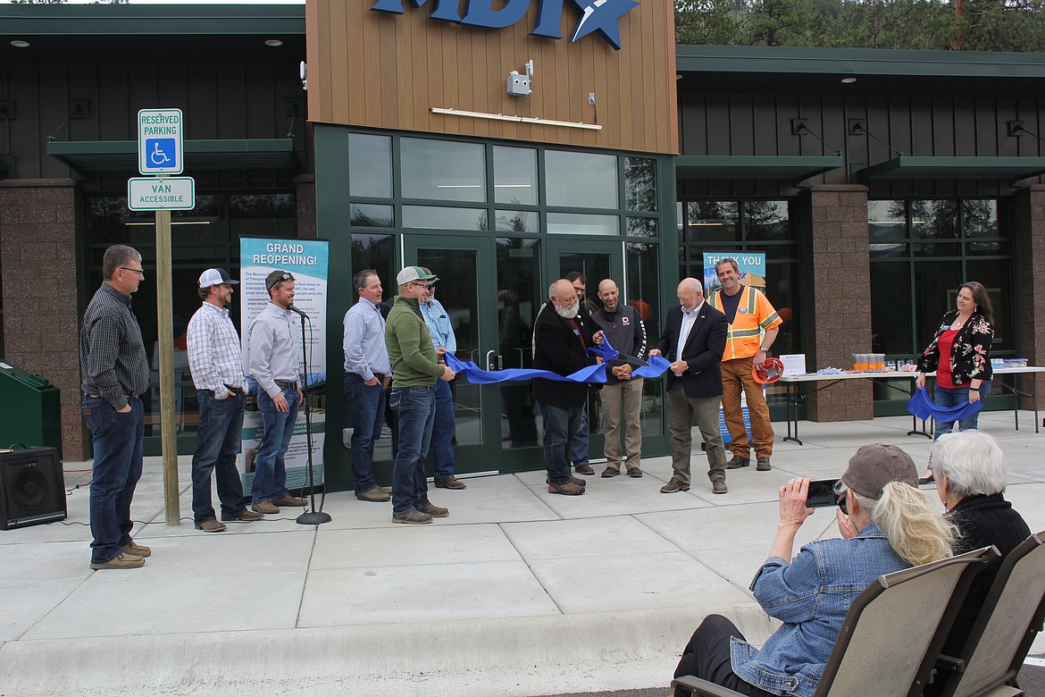 Denley Loge, Chairman of the Montana House of Representatives Transportation Committee, cuts the dedication ribbon as Malcolm ‘Mack’ Long, Director of the Department of Montana Transportation, holds the small end. Engineers, contractors, inspectors and DOT personnel were all smiles at the rededication of the Quartz Flats Rest Area on I-90. Both east and west bound areas closed last March and are now much larger for restroom facilities and more parking for tractor/trailers and passenger vehicles.