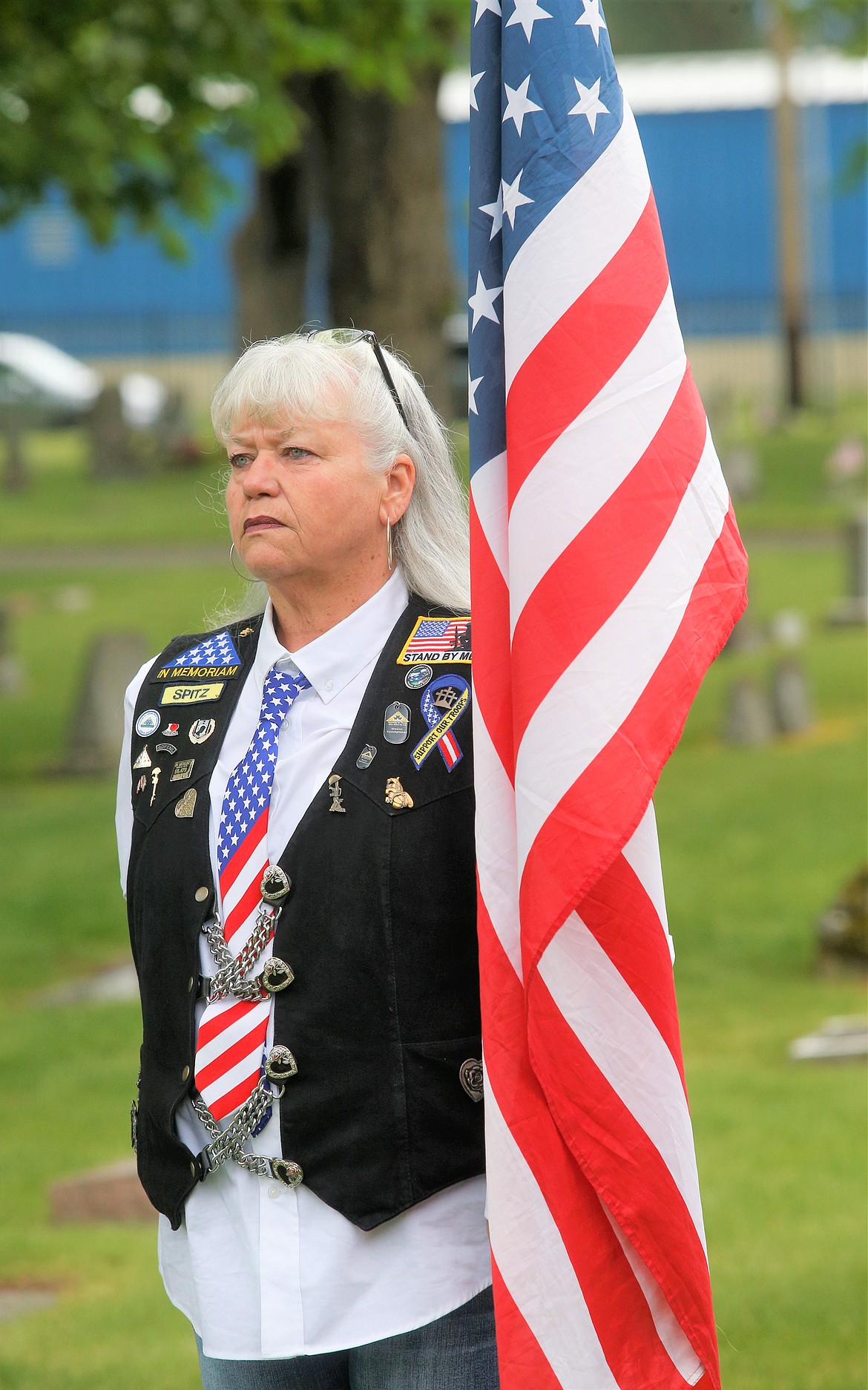 Donna Maddox with the Patriot Guard Riders stands with a flag during the Memorial Day ceremony on Sunday at St. Thomas Cemetery.